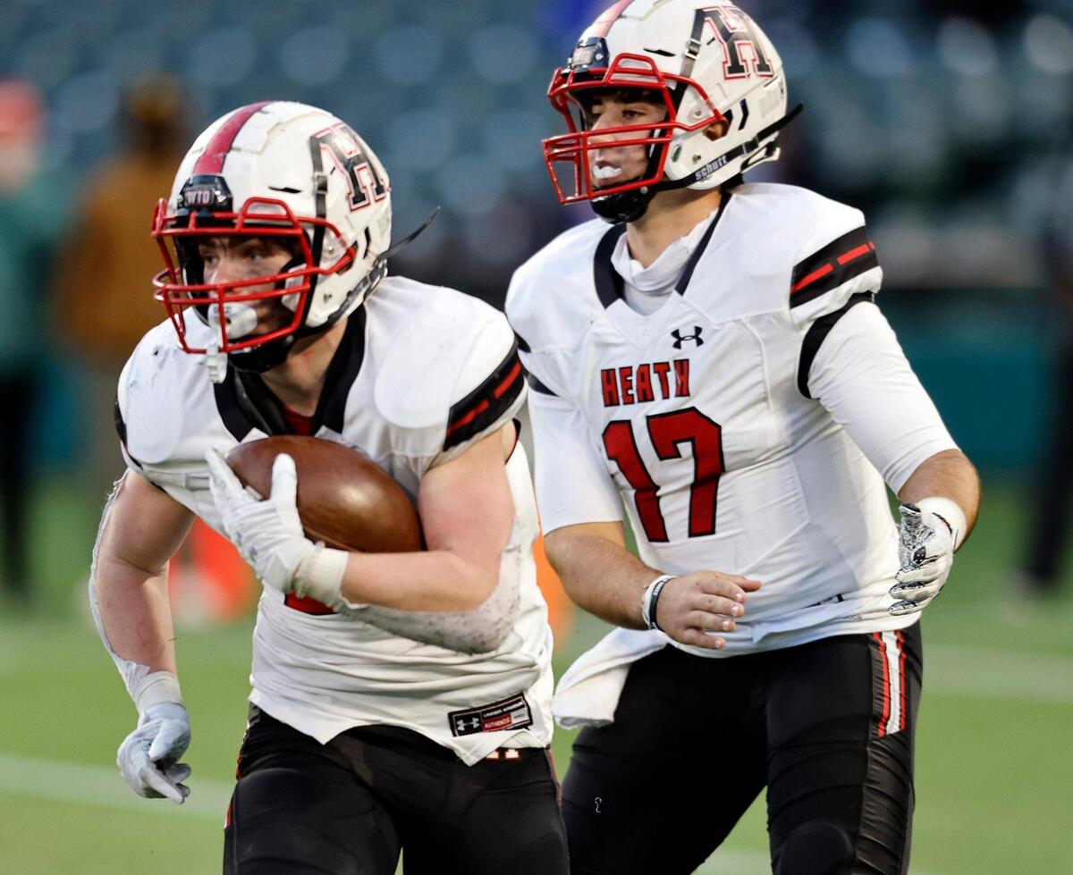 Rockwall Heath’s Preston Landis takes the hand off from Josh Hoover during the 6A division 2 quarterfinals at Globe Life Park in Arlington, Texas, Saturday, Jan. 02, 2021. With the game tied 21 after regulation Cedar Hill defeated Rockwall Heath 27-24. (Special to the Star-Telegram Bob Booth)