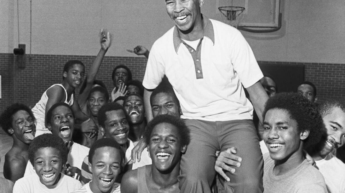 Coach Robert Hughes with his basketball players at Dunbar High School.