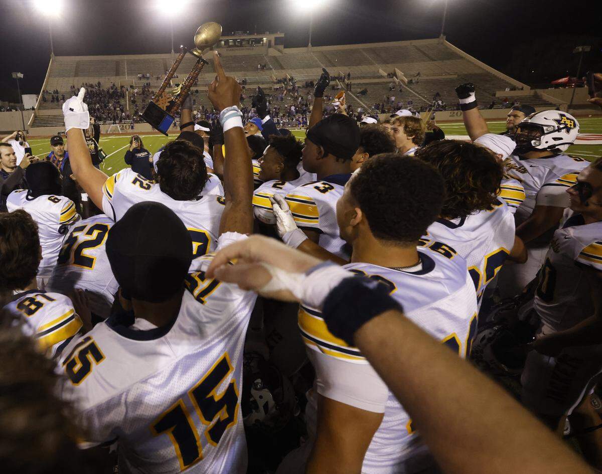 The Battle of the Bonfire trophy is raised after Arlington Heights defeated Paschal at Farrington Field in Fort Worth, Texas, Friday Nov. 07, 2025.