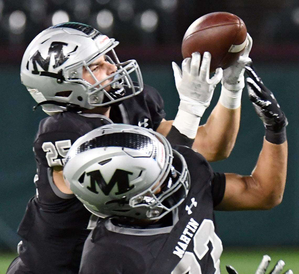 Arlington Martin’s Jake Landrum, left intercepts a South Grand Prairie pass over his teammate Brandon Smith in the first quarter of their District 8-6A football game at Choctaw Stadium in Arlington, Texas. Special/Bob Haynes