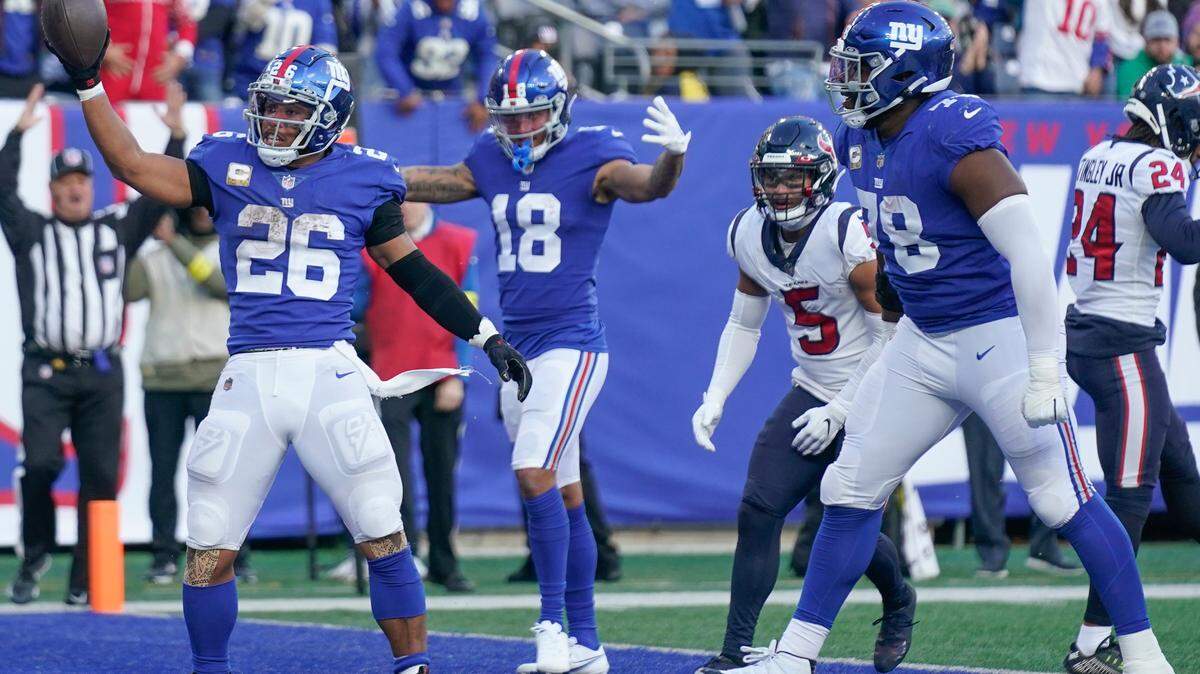 New York Giants running back Saquon Barkley (26), left, celebrates after scoring a touchdown against the Houston Texans on Sunday.