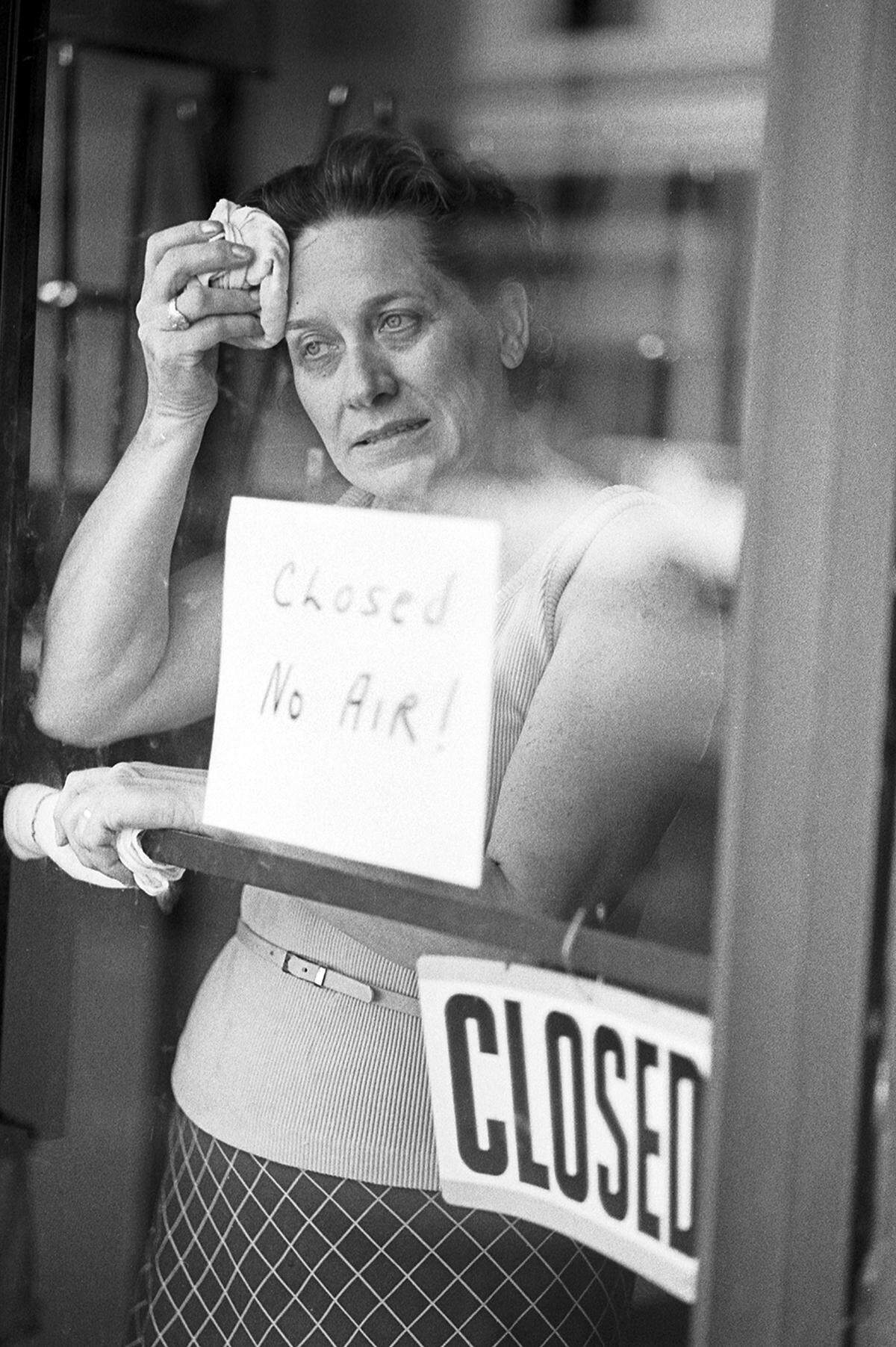 June 26, 1980: Maxine Harkridge, owner of Rusty’s Hot Dogs, stands next to a sign reading “Closed, no air!” and wipes sweat off her brow while waiting for the air conditioning repair person. Vince Heptig]