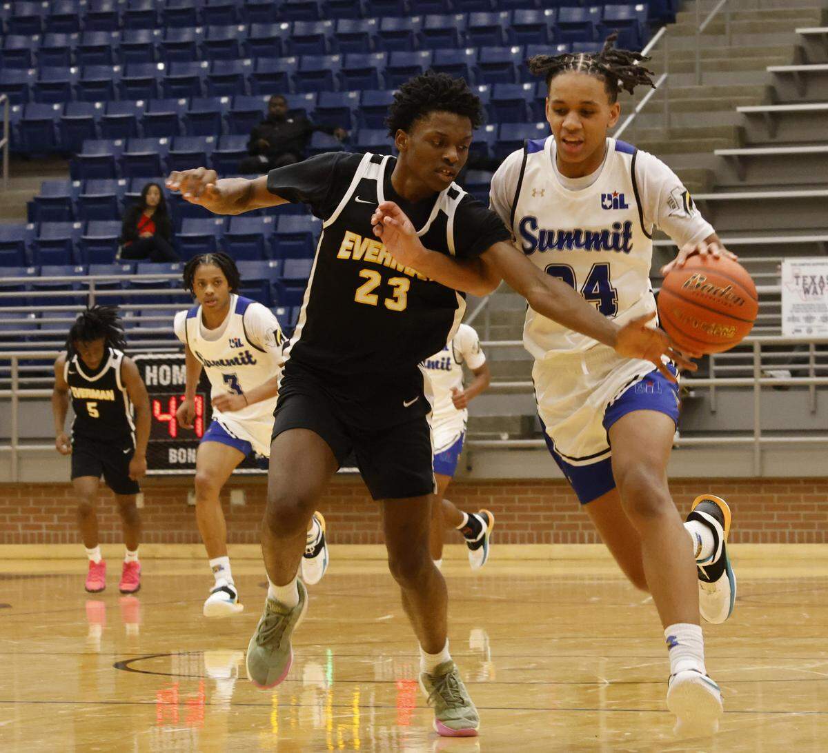 Everman forward Glory Makolo (23) reaches in on Mansfield Summit guard Joseph Creal (24) during the second half of a UIL boys basketball game between Everman and Mansfield Summit at Summit High School in Mansfield, Texas, Thursday Jan. 22, 2026