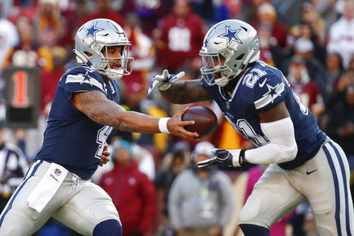 Dallas Cowboys quarterback Dak Prescott (4) hands off the ball to running back Ezekiel Elliott (21) during the first half of an NFL football game against the Washington Redskins, Sunday, Oct. 21, 2018 in Landover, Md.