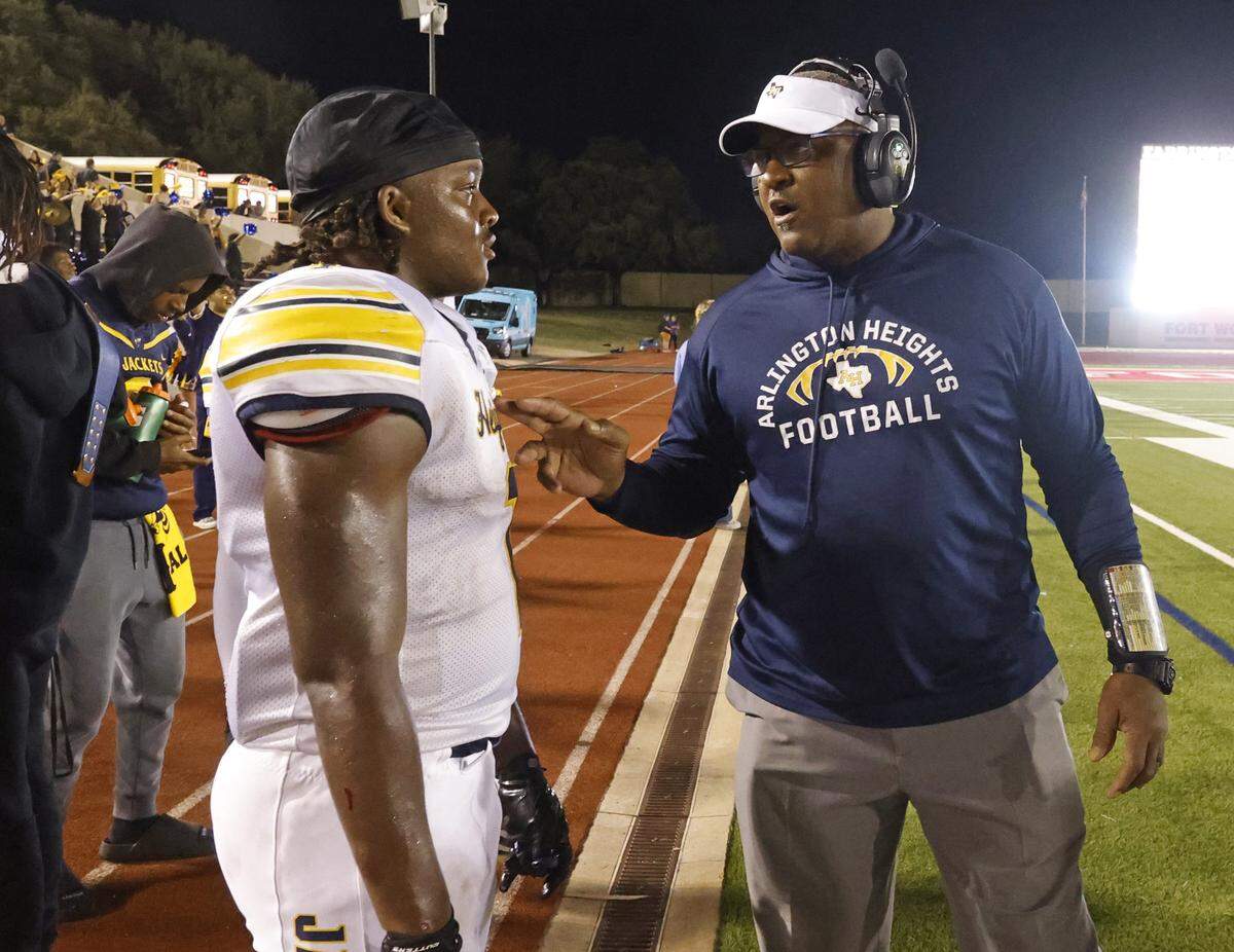 Arlington Heights head coach Curtis James talks with his son running back Carson James (1) near the end of a UIL football game between Arlington Heights and Paschal at Farrington Field in Fort Worth, Texas, Friday Nov. 07, 2025.