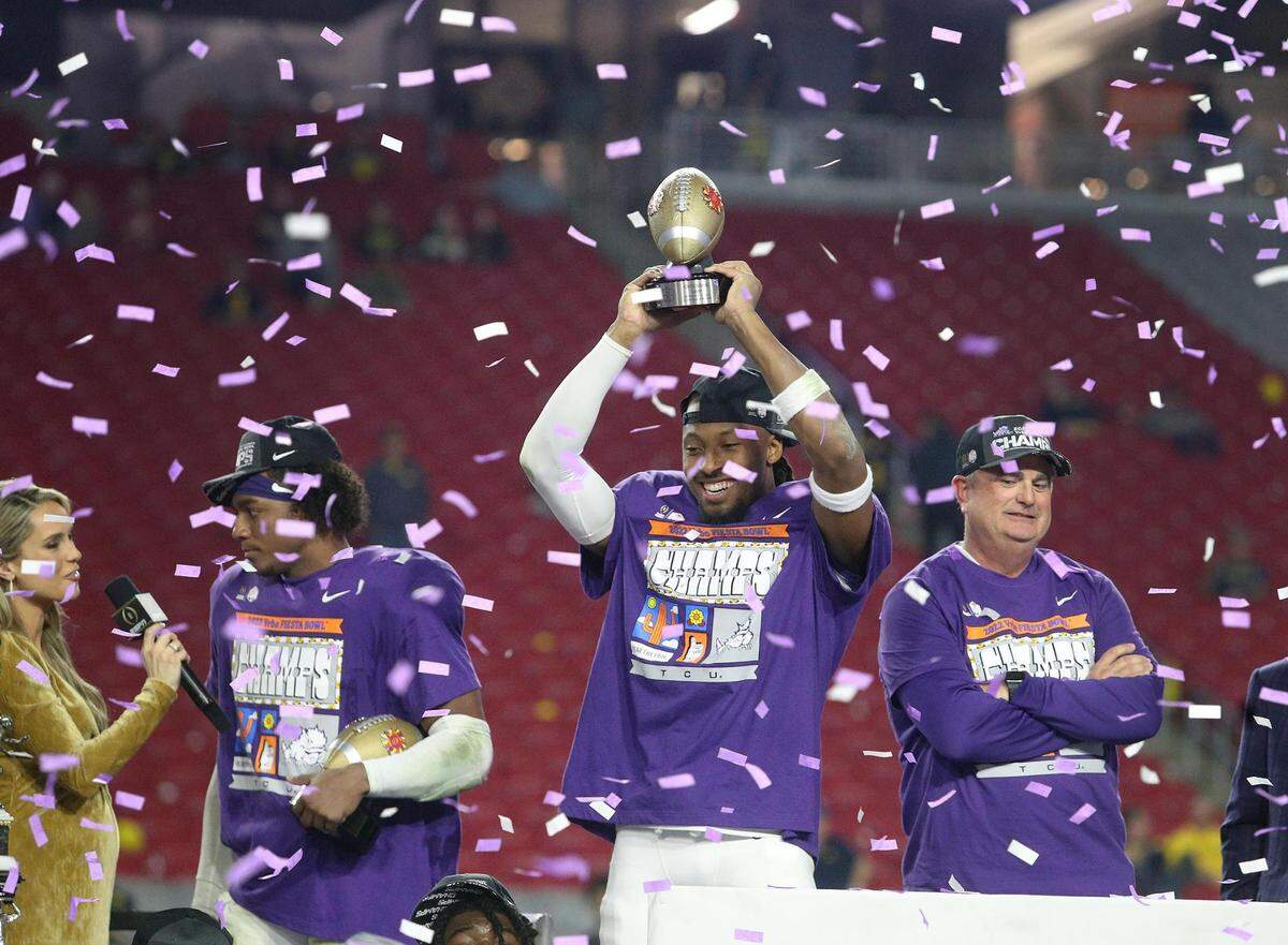 TCU wide receiver Quentin Johnston holds up the offensive MVP trophy at the Vrbo Fiesta Bowl at State Farm Stadium in Glendale, Ariz., on Saturday, December 31, 2022. TCU defeated Michigan to move onto the championship.