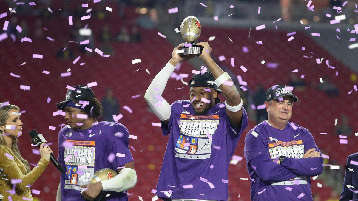 TCU wide receiver Quentin Johnston holds up the offensive MVP trophy at the Vrbo Fiesta Bowl at State Farm Stadium after TCU defeated Michigan to advance to the national championship.