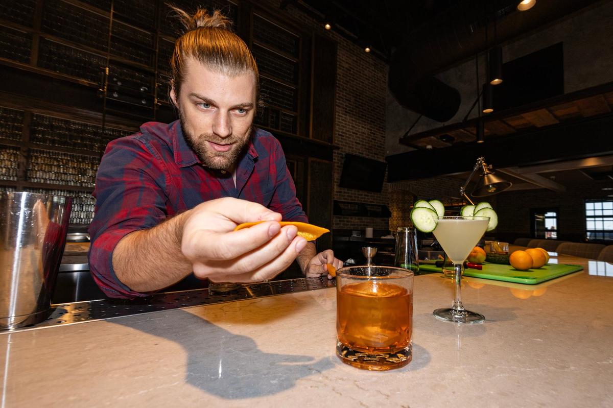 Alan Dean, the Concept Beverage Manager, makes the WC Old Fashioned and finishes it off with a spritz from the orange peel available at the new Whiskey Cake restaurant in Alliance.