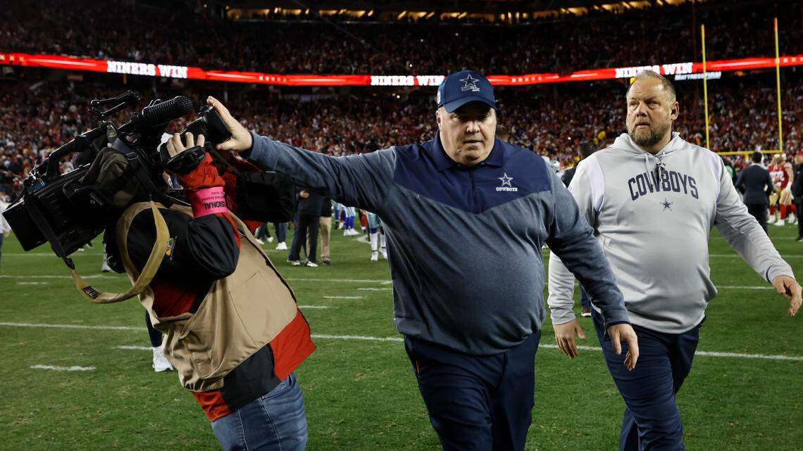 Dallas Cowboys head coach Mike McCarthy pushes a cameraman away while walking off the field Sunday after a playoff football game against the San Francisco 49ers.
