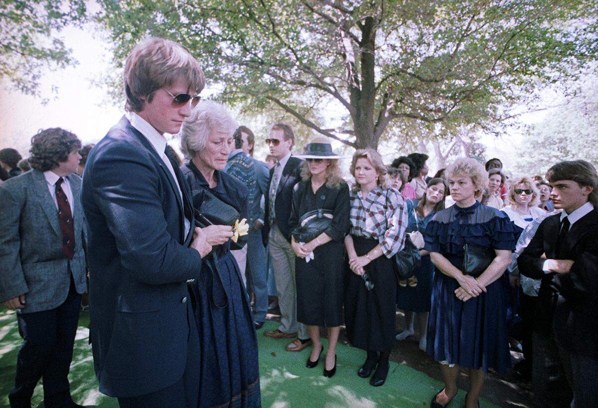 April 18, 1987: Doris Adkisson is seen being escorted to the gravesite by her son Kevin Von Erich at Grove Hill Memorial Park in Dallas during the funeral of her son, wrestler Mike Von Erich.