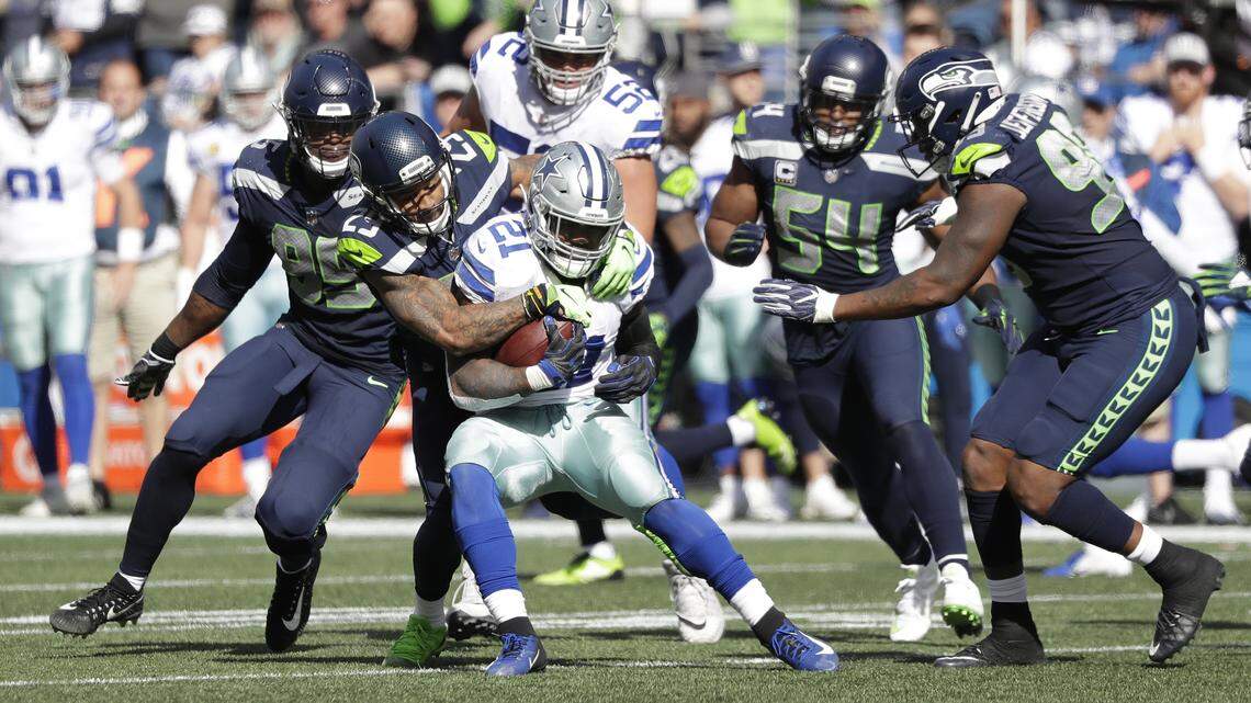 Seattle Seahawks free safety Earl Thomas, second from left, tackles Dallas Cowboys running back Ezekiel Elliott (21) during the first half of an NFL football game, Sunday, Sept. 23, 2018, in Seattle.