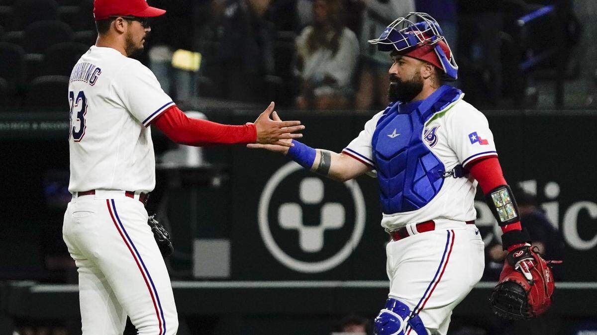Texas Rangers pitcher Dane Dunning (33) and catcher Sandy Leon (12) shake hands following the game against the Kansas City Royals at Globe Life Field.