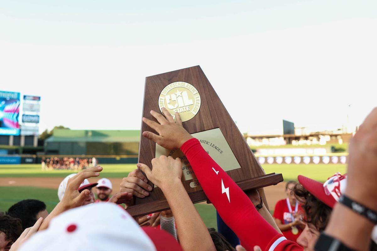 Grapevine players touch the trophy in celebration after defeating Kingwood Park 9-5 in the Class 5A Division II state championship game on Friday, June 6, 2025 at Dell Diamond in Round Rock, Texas.