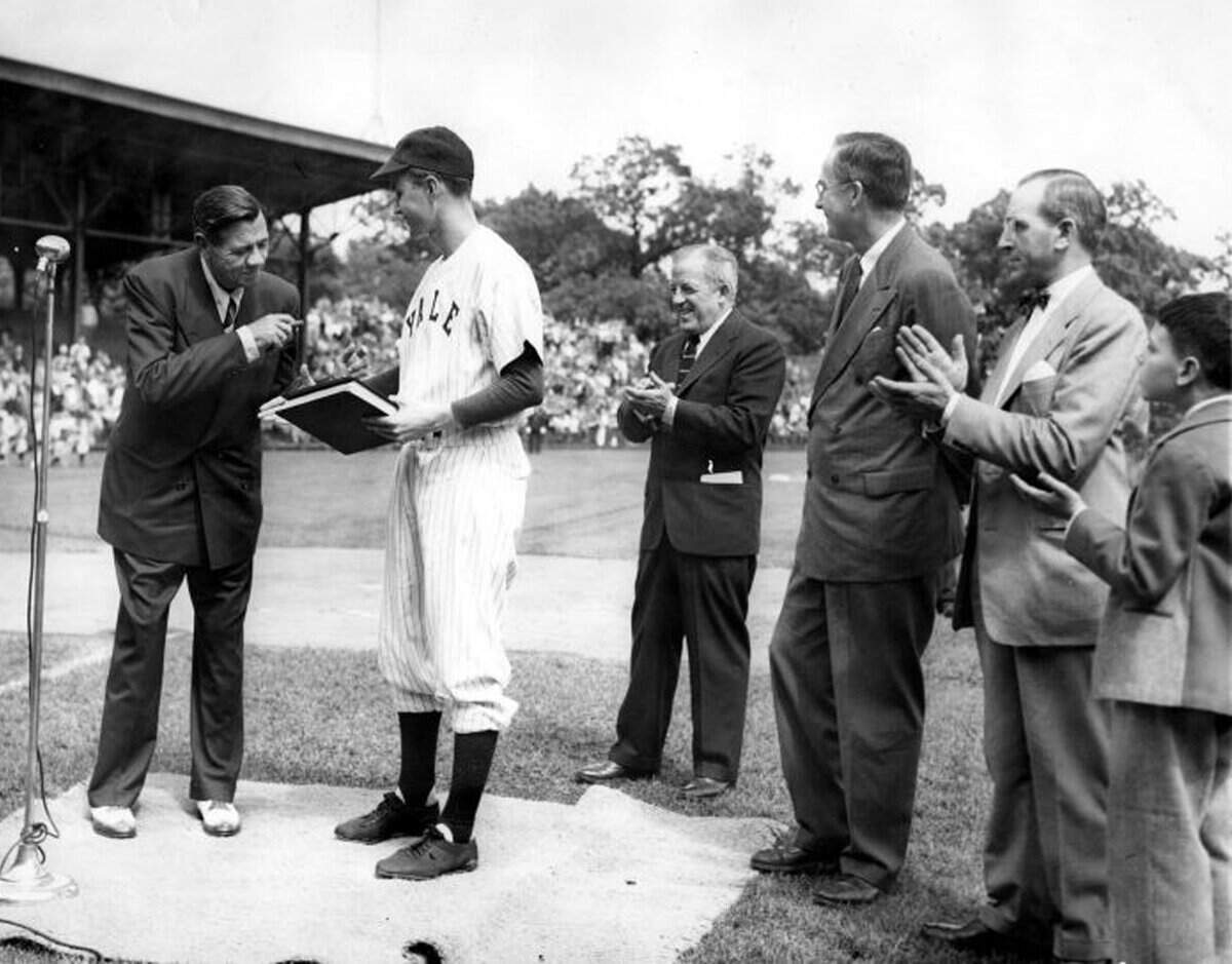 Baseball legend Babe Ruth presents his papers to Yale University in 1948. They are received by Yale baseball team captain, George Bush. Also present are: Bob Kiplurth, Yale Athletic Director; Professor James T. Babb, Yale University Librarian for Preservation; and Mayor Celentano and his son