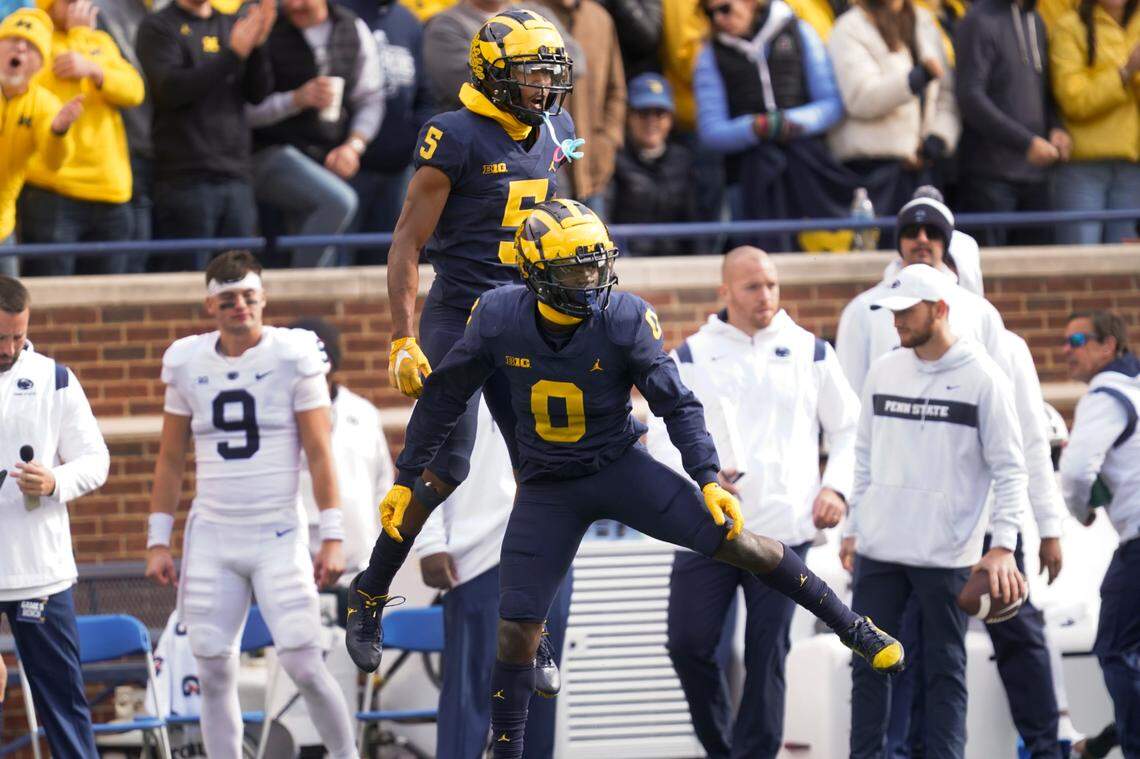Michigan defensive back Mike Sainristil (0) celebrates a play with DJ Turner (5) during their rout of Penn State.