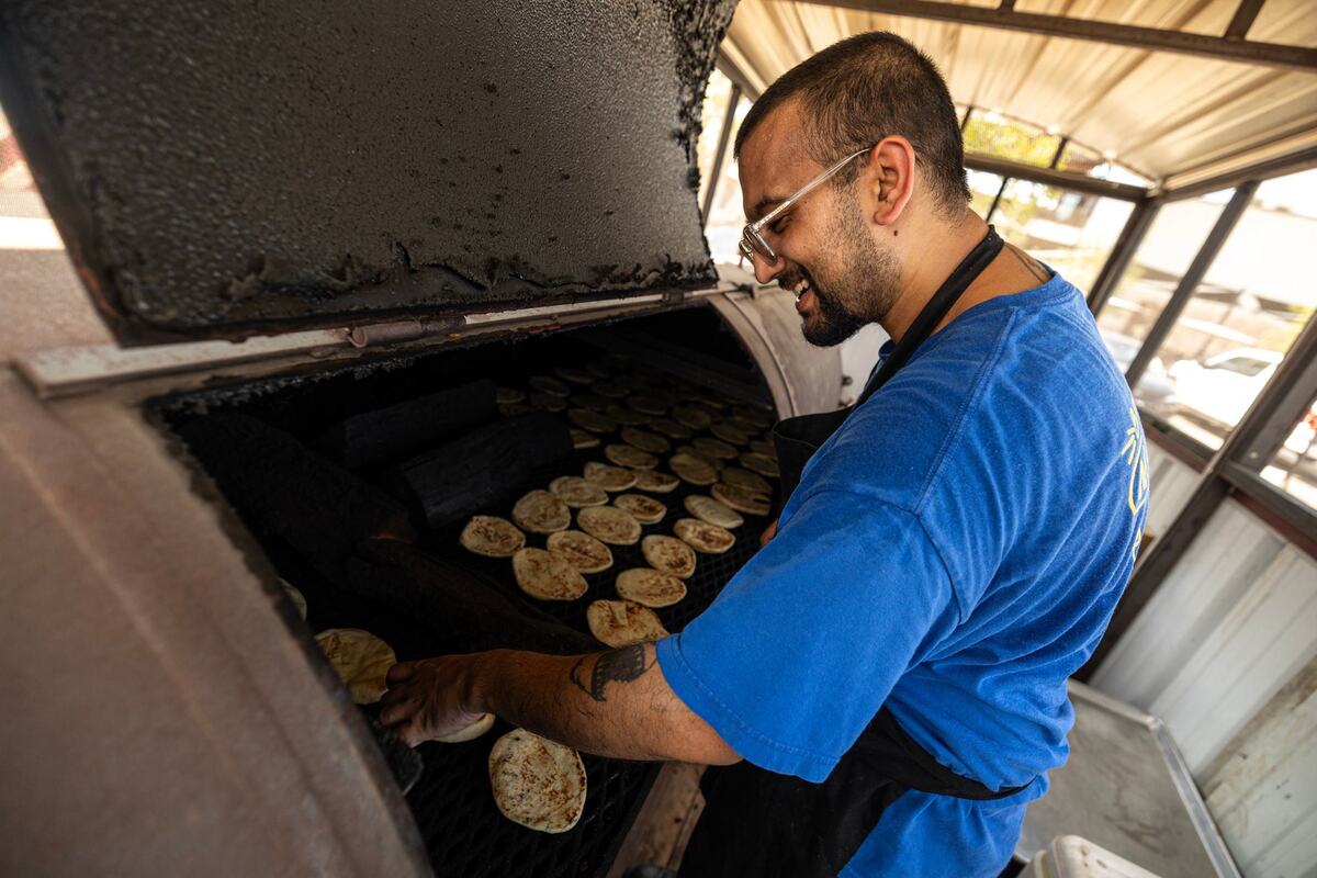 Usama Khalid, the lead pit hand at Sabar BBQ, flips the naan bread in the smoker prior to service at the Sabar BBQ trailer parked at the corner of E Vickery Street and S Main Street near downtown Fort Worth on Saturday, Aug. 23, 2024. The naan bread is heated in the smoker an hour before service to keep the bread hot.