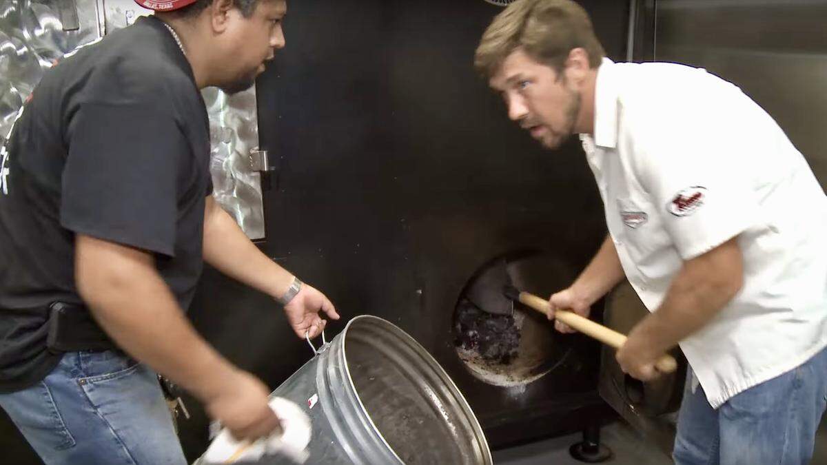 Lockhart Smokehouse workers load hot coals from the Dallas location into the pit at the new Arlington location.