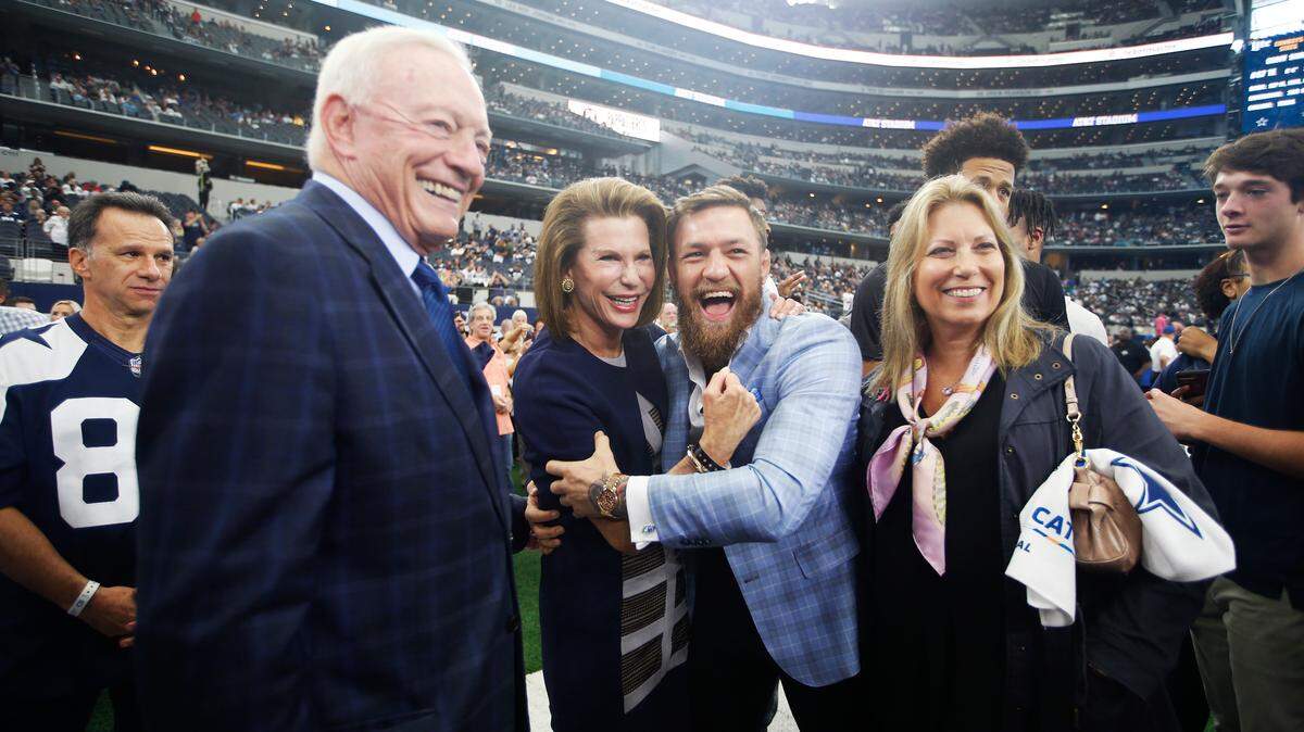 (L to R) Dallas Cowboys owner Jerry Jones, Susan G. Komen for the Cure Founder Nancy Brinker and UFC fighter Conor McGregor pose for photos before an NFL football game against the Jacksonville Jaguars in Arlington, Texas, Sunday, Oct. 14, 2018. (AP Photo/Jim Cowsert)