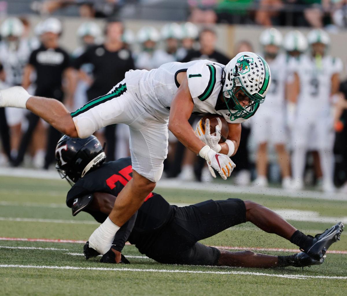 Southlake running back Riley Wormley (1) is tripped up by Trinity defensive back Caleb Adom (25) during a UIL 6A Conference football game at Pennington Field in Bedford Texas, Friday, Sept. 20, 2024.