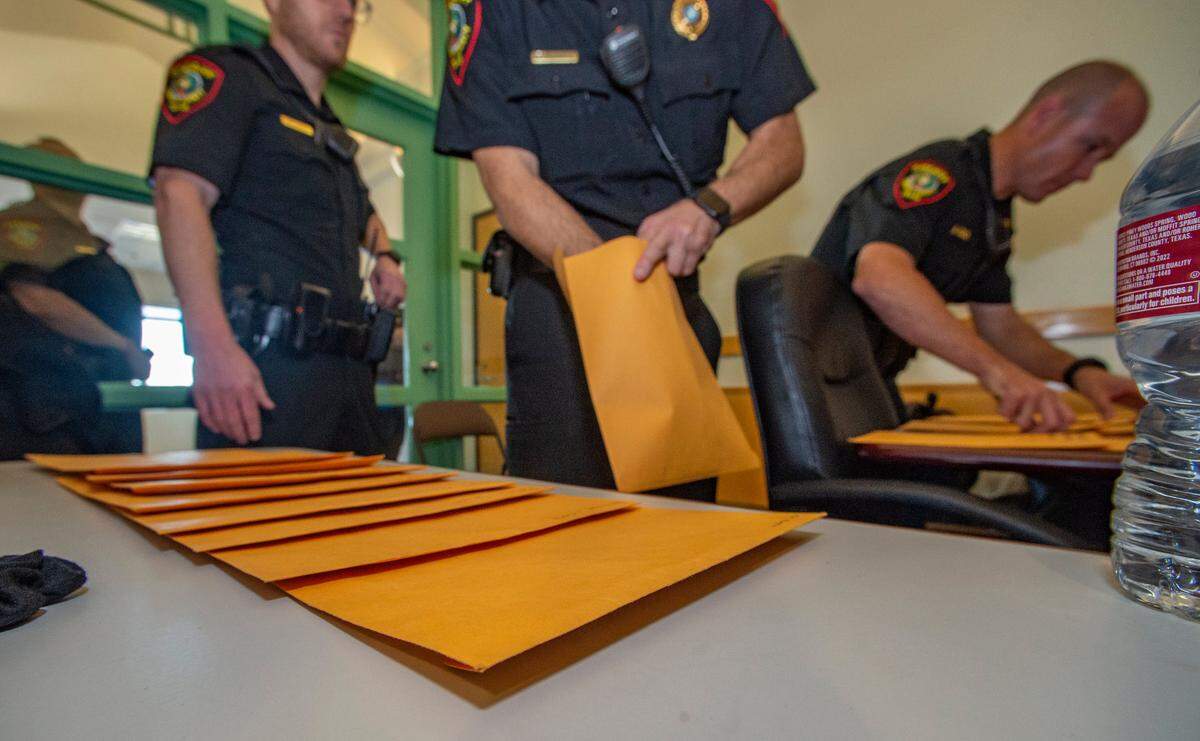 Tarrant County sheriff’s deputies collect electronic equipment before letting people in the courtroom to hear the verdict in former Fort Worth police officer Aaron Dean’s murder trial Thursday, Dec. 15, 2022. The jury found Dean guilty of the lesser charge of manslaughter.