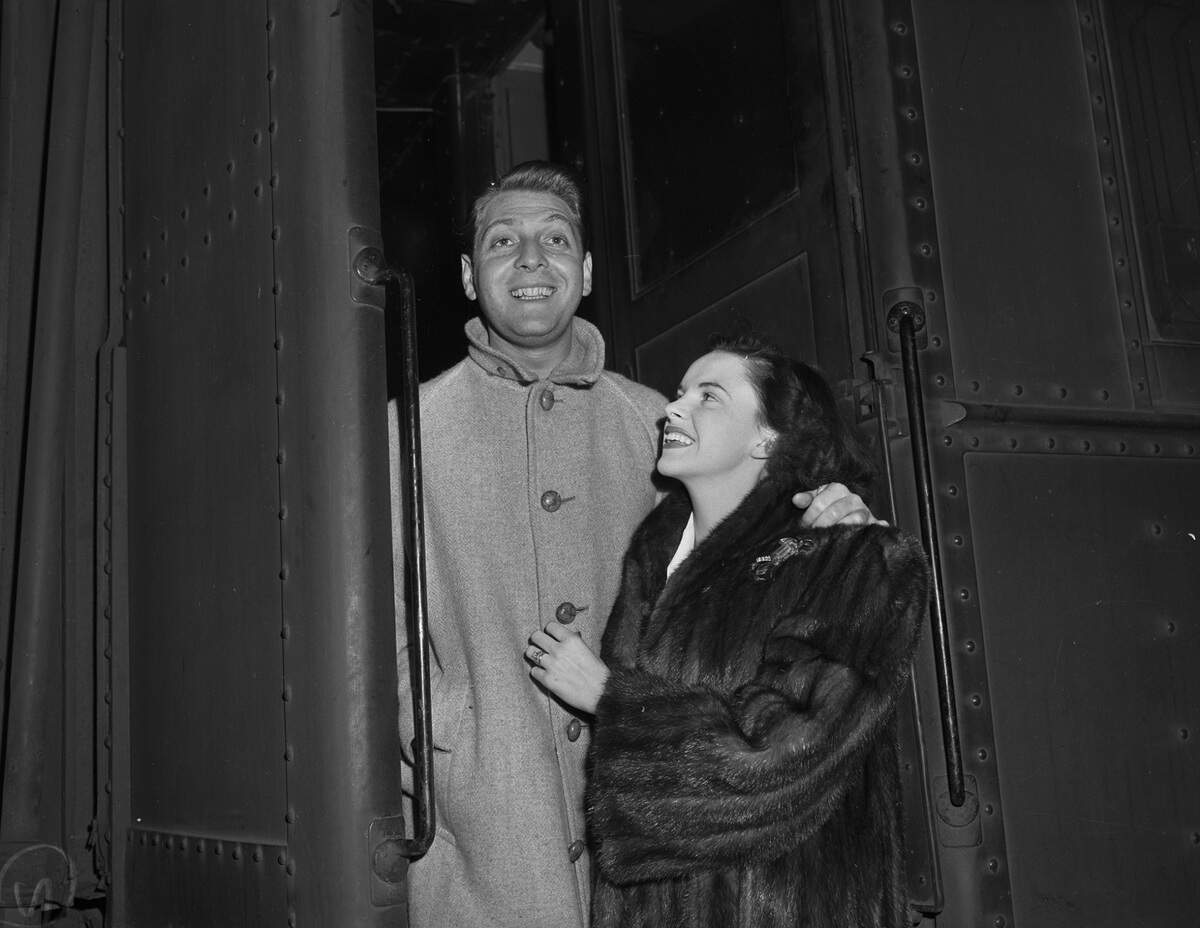 Rose is dressed in a buttoned winter coat. Miss Garland is wearing a fur coat, and a brooch. 