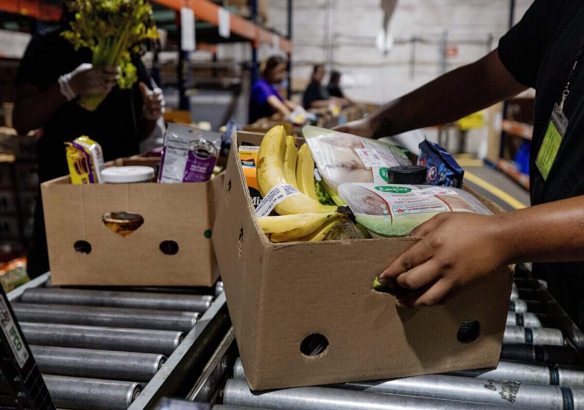 Volunteer Javier Garcia places a box full of food on a conveyor belt at the Community Food Bank of Fort Worth on June 15, 2026. The Community Food Bank states that the best way to support them is through donations and volunteering.