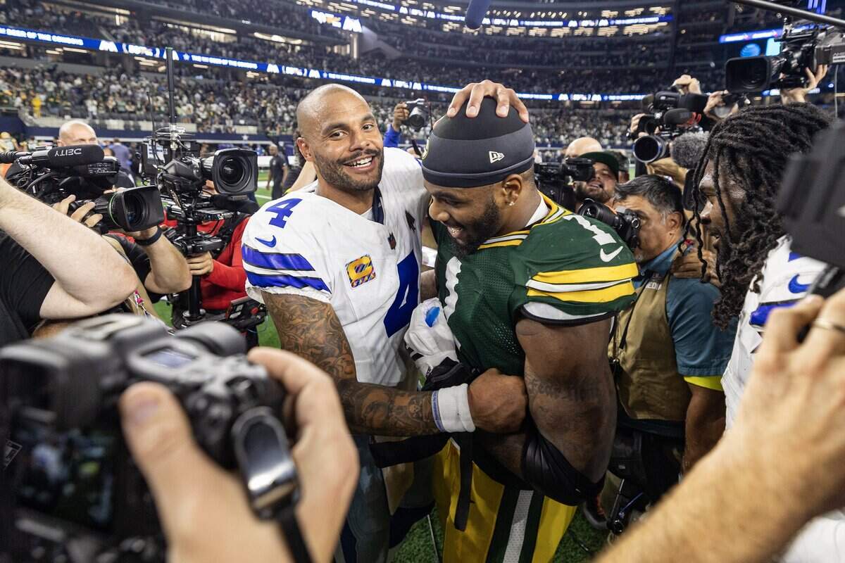 Cowboys quarterback Dak Prescott (4) greets his former teammate and Packers defensive end Micah Parsons following the 40-40 tie on Sunday night at AT&T Stadium.