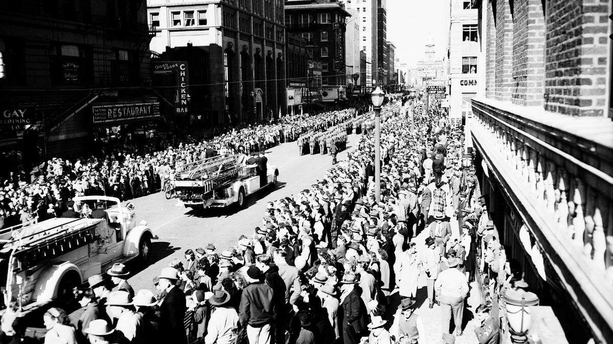 Crowds gather on both sides of Main Street in Fort Worth Nov. 11, 1946, to watch the first Armistice Day parade after World War II. Two firetrucks can be seen behind marching troops passing the review stand at Hotel Texas.