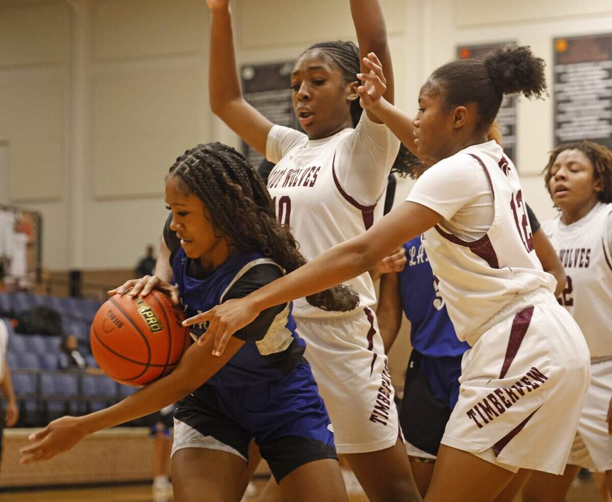 Mansfield Summit guard Aryn Williamson (2) gets an offensive rebound in front of Mansfield Timberview point Shanella Tadja (10) and guard Sydney Gamble (12) during the first half of a UIL girls basketball game at Mansfield Timberview High School in Arlington, Texas, Tuesday Feb. 10, 2026.
