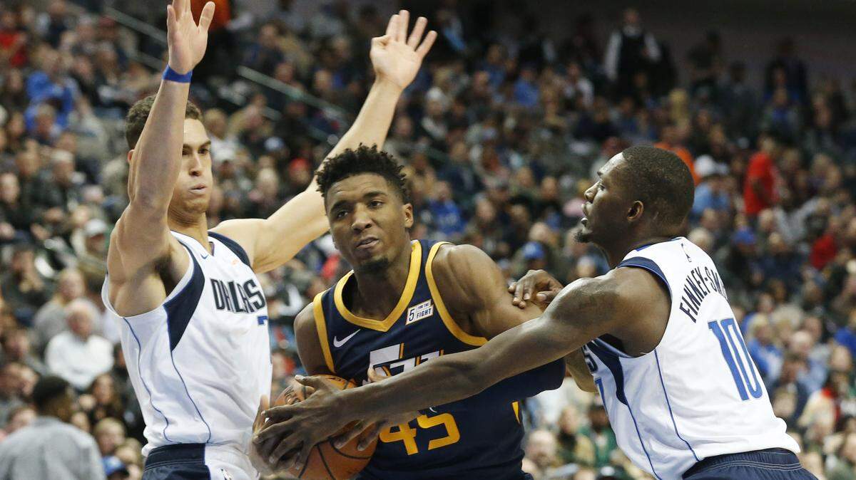 Dallas Mavericks forward Dwight Powell (7) and forward Dorian Finney-Smith (10) surround Utah Jazz guard Donovan Mitchell (45) during the second half Wednesday. Dallas held Utah to 22 points in the second half in a 118-68 victory.