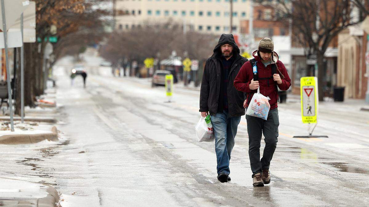 Pedestrians make their way on a melted section of Magnolia Street on Wednesday. North Texas counties are under an ice storm warning until 9 a.m. Thursday, according to the National Weather Service.