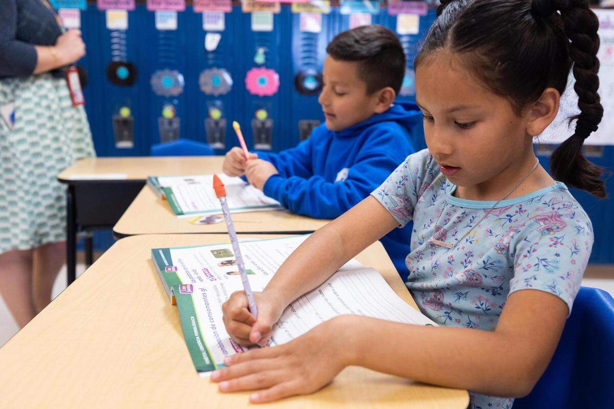 Second-graders Nicholas Lugo and Alayna Suarez work in their workbooks during a bilingual class at M. H. Moore Elementary in Fort Worth.
