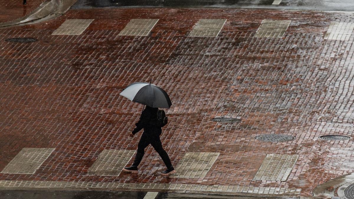 A pedestrian crosses the street in the rain at Main Street in downtown Fort Worth on Tuesday, Sept. 3, 2024.