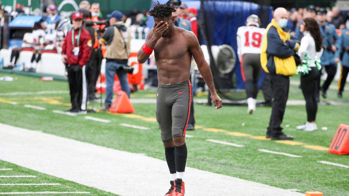 Tampa Bay Buccaneers wide receiver Antonio Brown wipes his face as he leaves the field after throwing his equipment into the stands while his team is on offense during the third quarter Sunday at MetLife Stadium in East Rutherford, N.J. The Bucs said Brown was no longer with the team after the game.