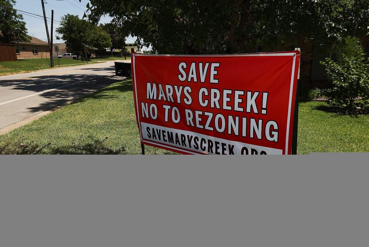 A sign near homes along Mary's Creek in Benbrook states its opposition to rezoning for development in its floodplain on Wednesday, July 30, 2025.