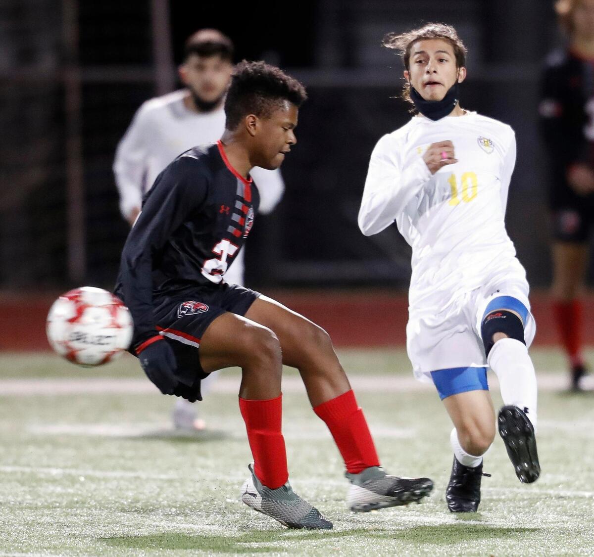 Everman’s Yahir Romero (10) kicks the ball in front of Legacy’s Joshua Omorodion (25) during a district 8-5A high school soccer game at Mansfield Legacy High School in Mansfield, Texas, Wednesday, March 03, 2021. Legacy defeated Everman 5-1. (Special to the Star-Telegram Bob Booth)