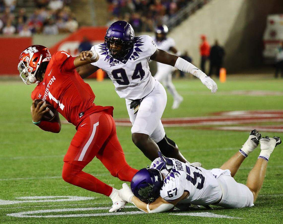 HOUSTON, TEXAS - SEPTEMBER 16: Donovan Smith #1 of the Houston Cougars is brought down by Johnny Hodges #57 of the TCU Horned Frogs and Micheal Ibukun-Okeyode #94 during the second half at TDECU Stadium on September 16, 2023 in Houston, Texas. (Photo by Bob Levey/Getty Images)