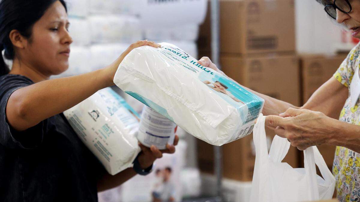 Leidy Hilton, left, and Jane Fairweather, volunteers at Community Crossroads, gather diapers during the outreach center’s weekly diaper and formula distribution on July 31, 2023, in Fort Worth. 
