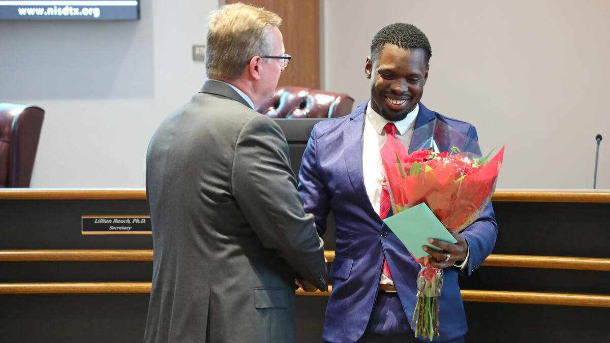 Jonathon Warren, right, a former Northwest High School student and U.S. Navy veteran, shakes hands with school district Superintendent Ryder Warren after receiving his diploma through post-secondary academic progress.
