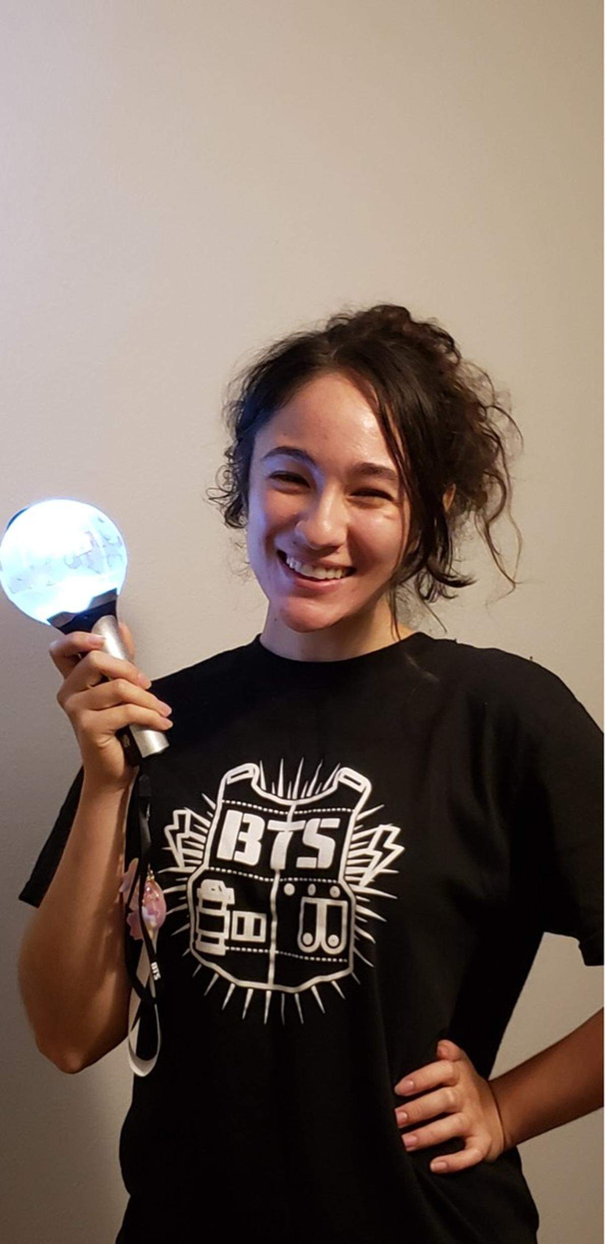 Lauren Pinto, 23, holding a BTS light stick known as an Army Bomb, ahead of a concert.