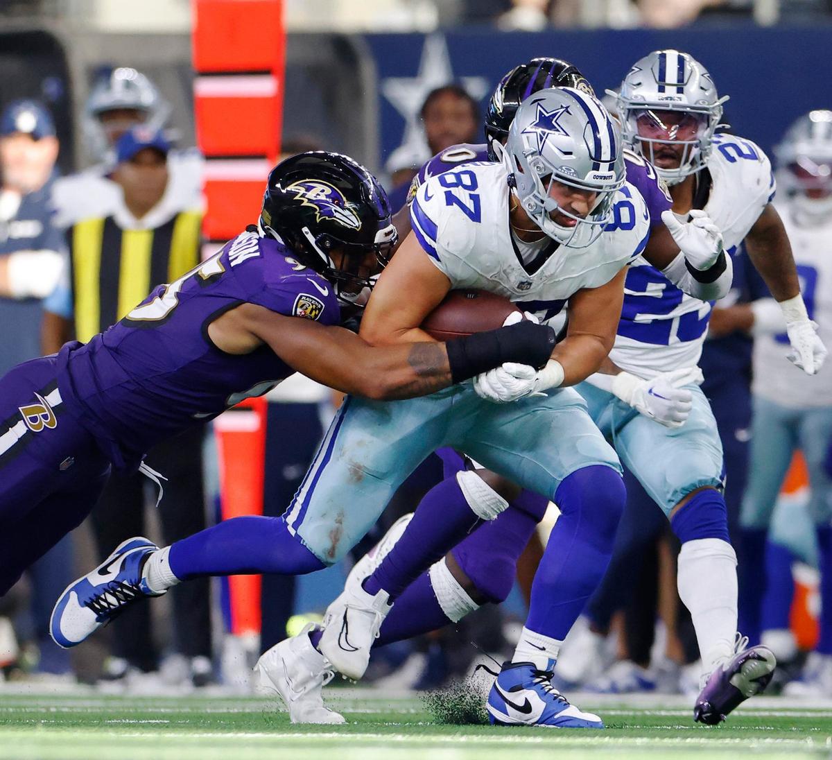 Dallas Cowboys tight end Jake Ferguson runs the ball while Baltimore Ravens’ Tavius Robinson gets his arms around him on Sunday, Sept. 22, 2024 at AT&T Stadium in Arlington.