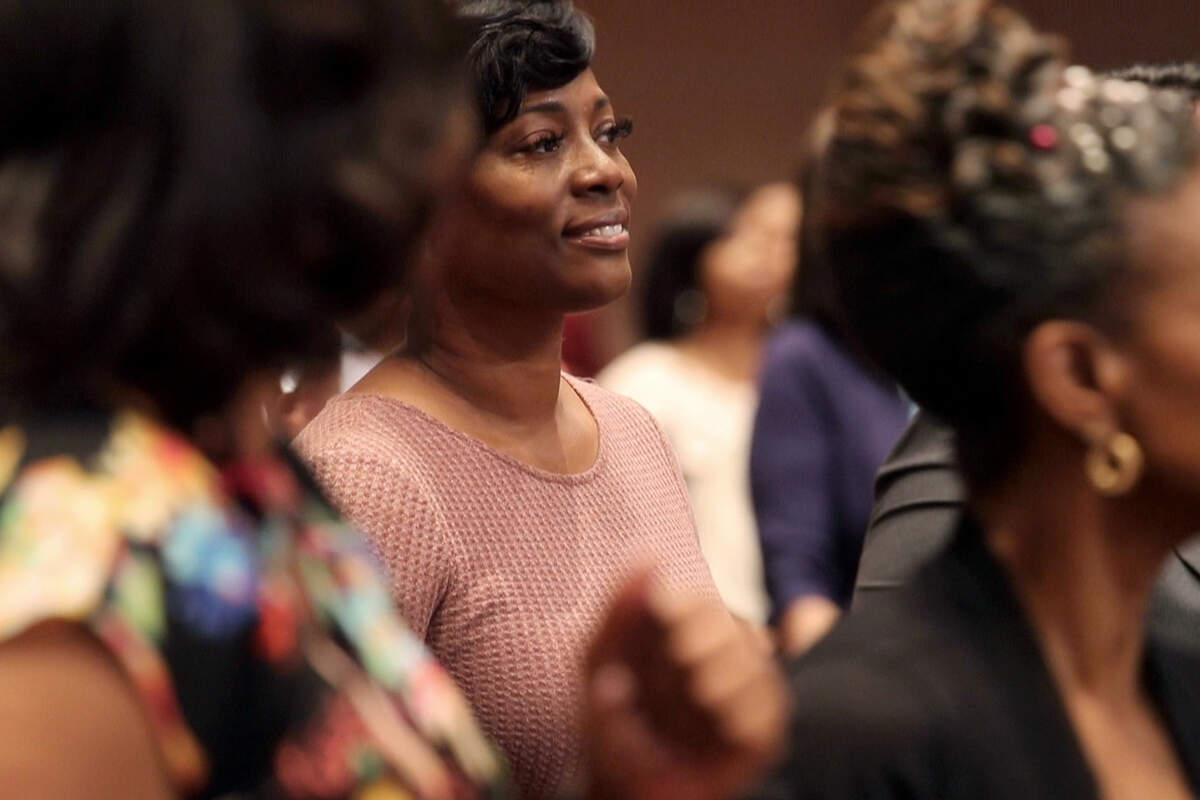 Crystal Mason, a Texas woman sentenced for illegally voting, says she was targeted and is appealing her state conviction. Mason stands near her family and friends during church service May 26, 2019, in Dallas.