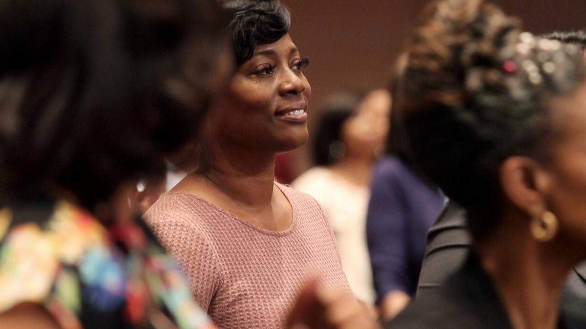 Crystal Mason, a Texas woman sentenced for illegally voting, says she was targeted and is appealing her state conviction. Mason stands near her family and friends during a church service May 26, 2019, in Dallas.