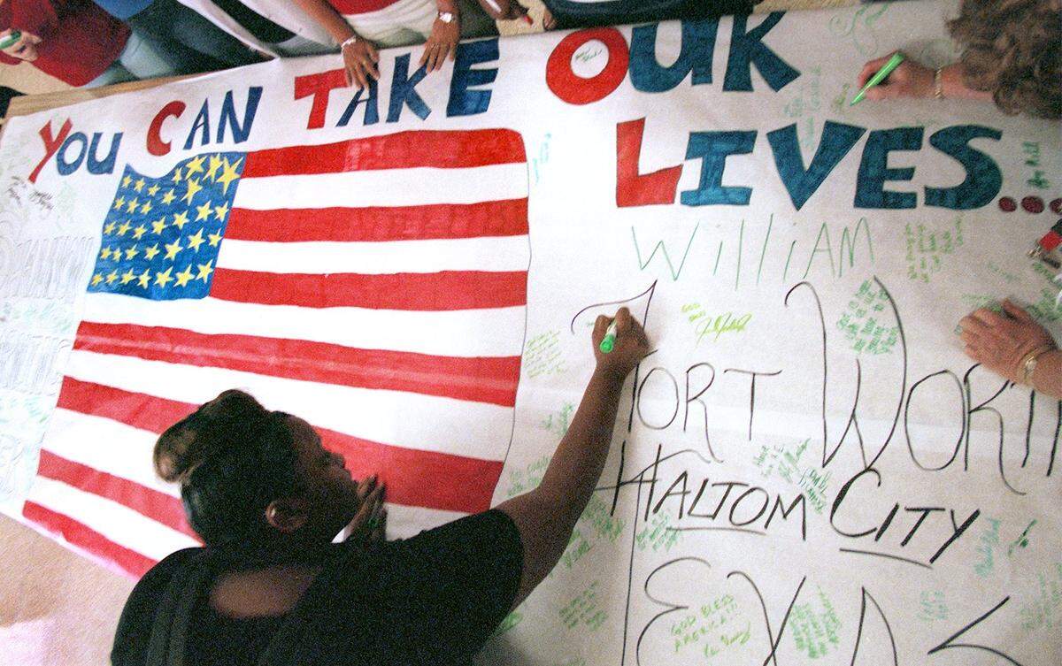 Tina Visor, a junior at the Shannon Learning Center in Haltom City, signs a note with the other students and faculty on a banner the reads, ‘You can take our lives but you cannot take our freedom’. The banner was supposed to be delivered to American Airlines on Sept. 12, 2001.