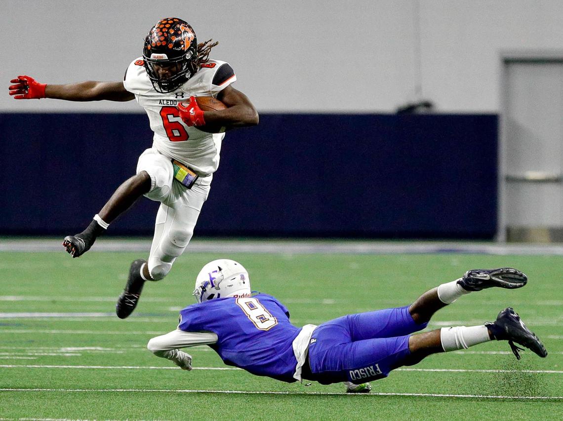 Aledo running back Demarco Roberts (6) hops over Frisco defensive back Trent Bryant (8) during the first half of the 5A Division II Regional round high school football playoffs, December 24, 2020, played at The Ford Center at the Star in Frisco, Tx. (Steve Nurenberg Special to the Star-Telegram)