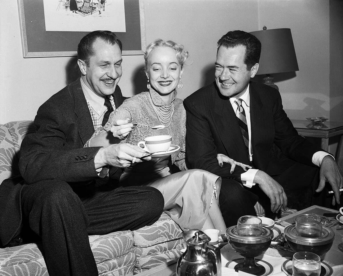 April 14, 1953: Stars of the 3-D shocker, “House of Wax”, enjoyed morning coffee in Fort Worth before personal appearances at the Worth Theater with the movie. Carolyn Jones sweetens up the coffee for Vincent Price, left, and Frank Lovejoy.