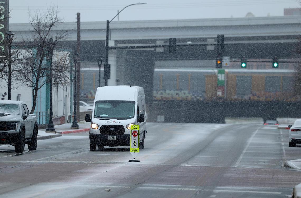 Snow falls as a vehicle makes its way south on South Main Street on Thursday, Jan. 9, 2025, in Fort Worth.