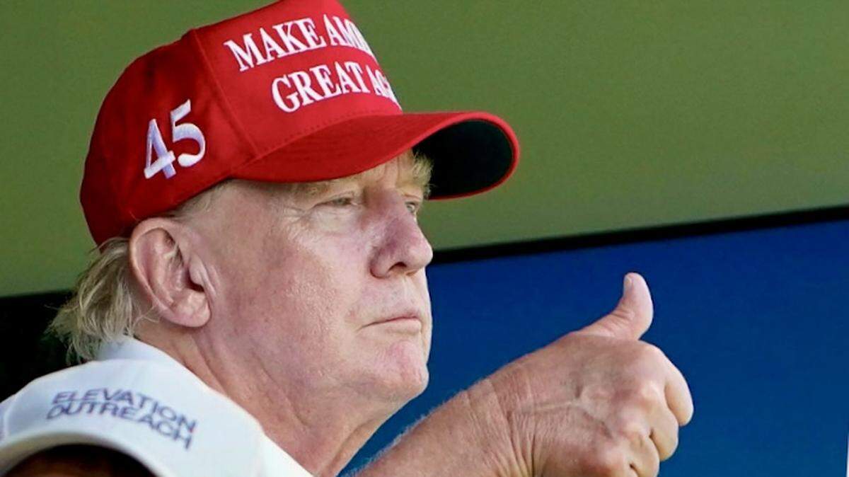 Former President Donald Trump gestures to golfer Dustin Johnson on the 18th green during the final round of the LIV Golf Bedminster tournament at Trump National Bedminster August 13, 2023.