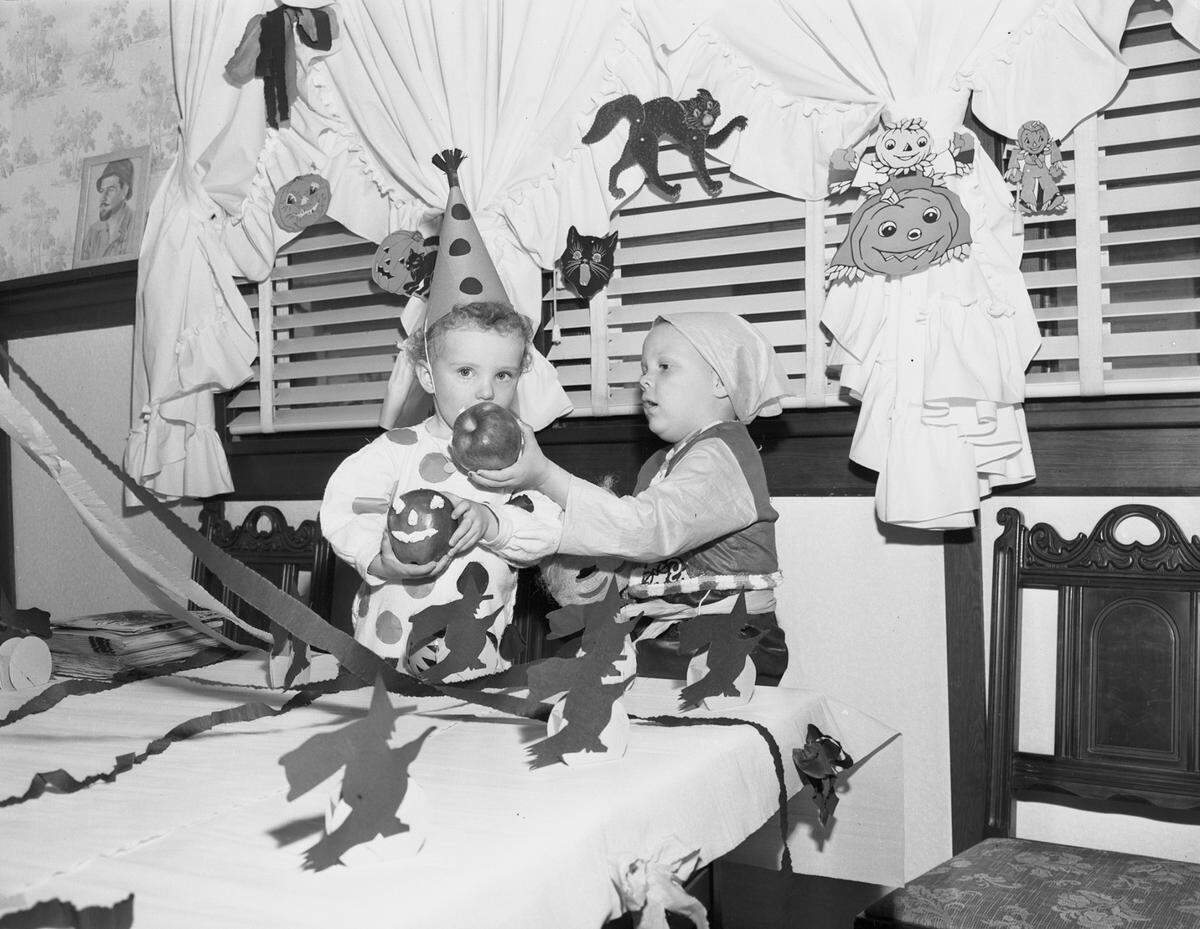 Oct. 31, 1946: Freddie Notley, son of Mr. and Mrs. Fred Notley, offers a bite of his red-faced apple to Camille Bridget, daughter of Capt. and Mrs. H. B. Bridget.