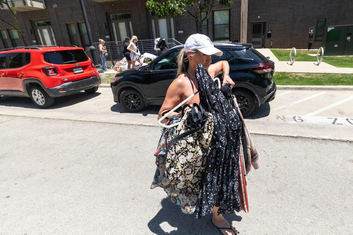 Christina Engel, a resident of The Cooper apartments, helps Gretchen Rea pack Rea’s belongings during a protest outside The Cooper apartments in Fort Worth on July 23. After waiting for more than a month for access, Rea evaded security, entered her apartment unit, and tossed multiple belongings out onto the sidewalk.
